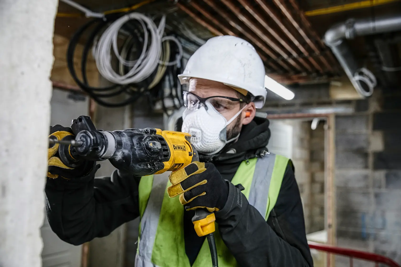 A DEWALT D25133K corded rotary hammer drill with a black and yellow design, featuring a side handle and depth gauge.