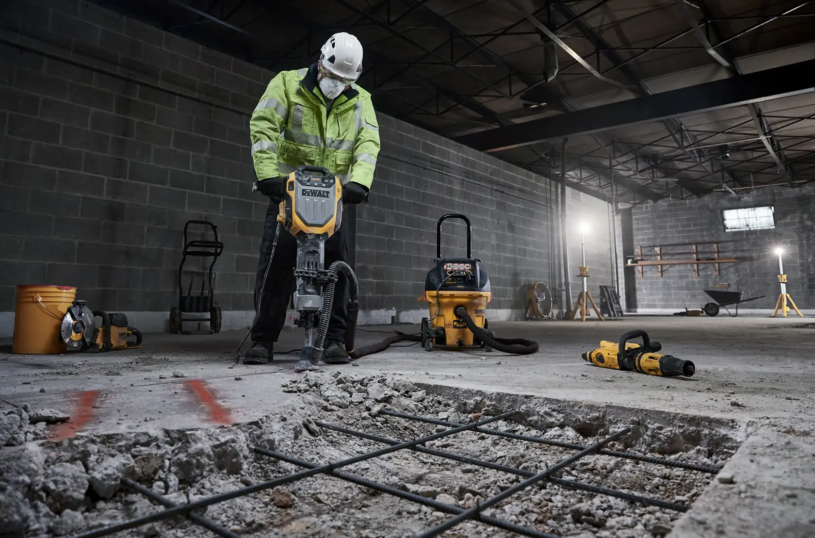 DEWALT D25966, D25966-B2 usados en obra, rompiendo piso de concreto con equipo de seguridad.
