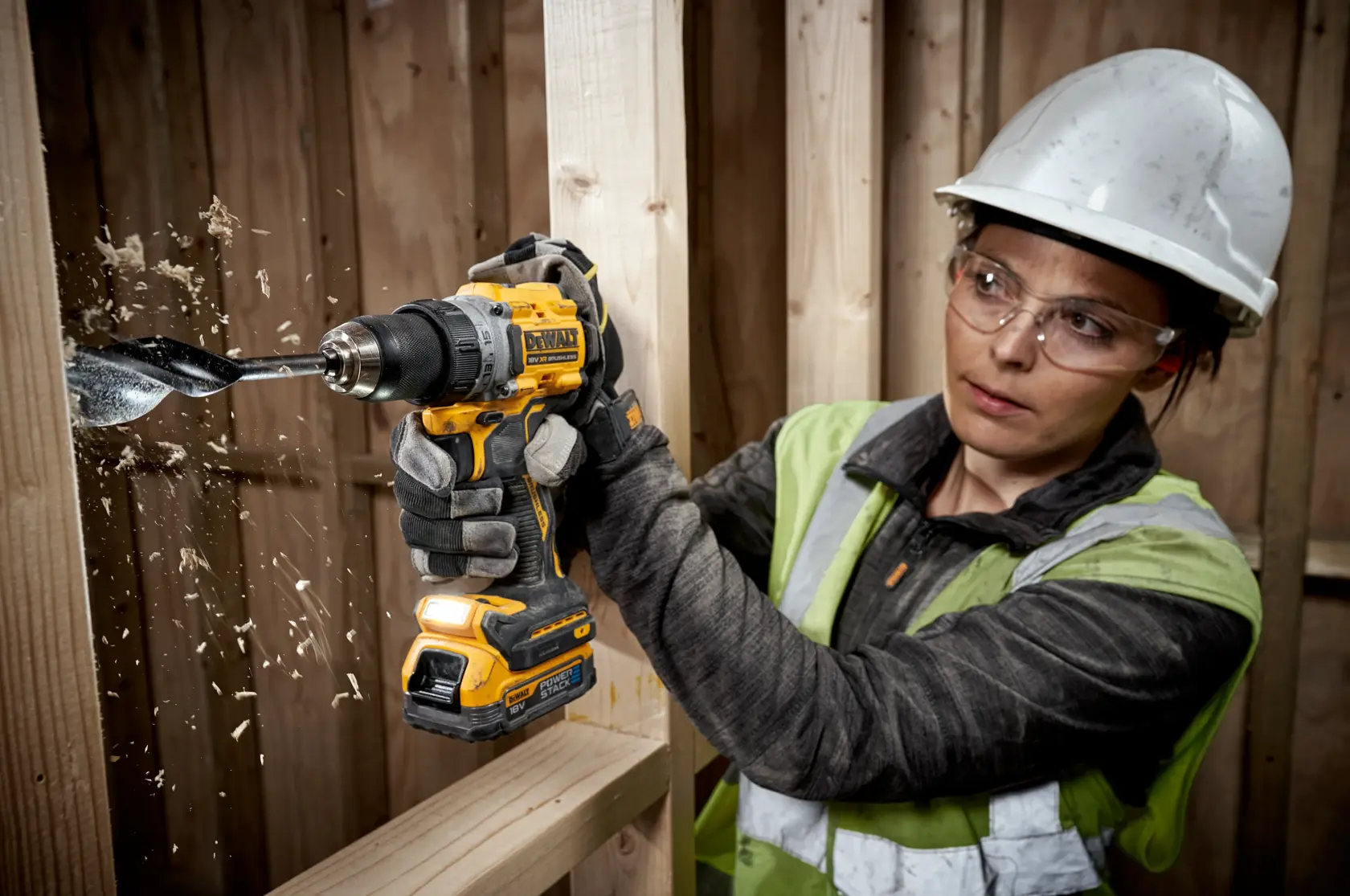 Imagen en primer plano de una batería de iones de litio DEWALT 18V Powerstack. La batería es compacta, de color amarillo y negro, y diseñada para herramientas eléctricas. El texto promocional en la parte inferior destaca esta batería como una revolucionaria XR 18V Powerstack compacta, indicando que DEWALT es la primera marca de herramientas eléctricas del mundo en usar baterías con celdas apiladas en bolsas, diseñadas para la industria de la construcción.