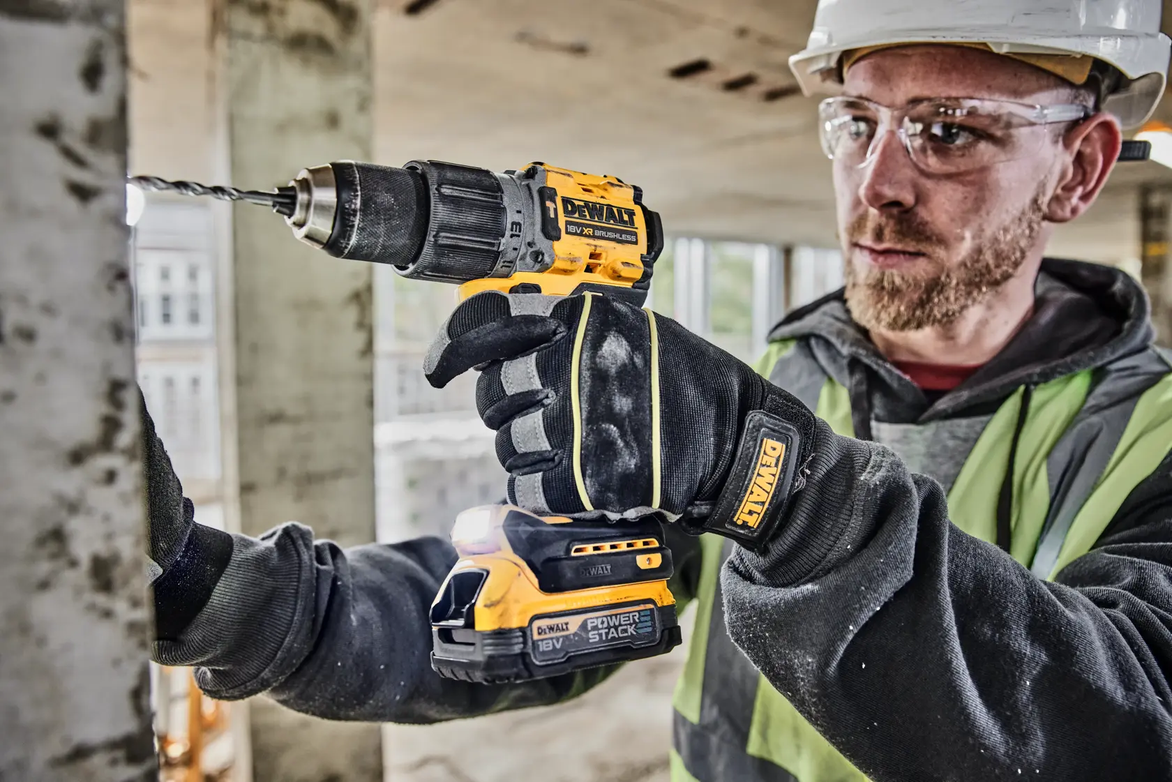 Imagen en primer plano de una batería compacta de iones de litio DEWALT 18V XR Powerstack. El fondo muestra efectos de luz azul. El texto destaca que es una batería compacta revolucionaria y menciona que DEWALT es la primera marca de herramientas eléctricas en el mundo en utilizar tecnología de celdas apiladas en bolsas, diseñada para la industria de la construcción.