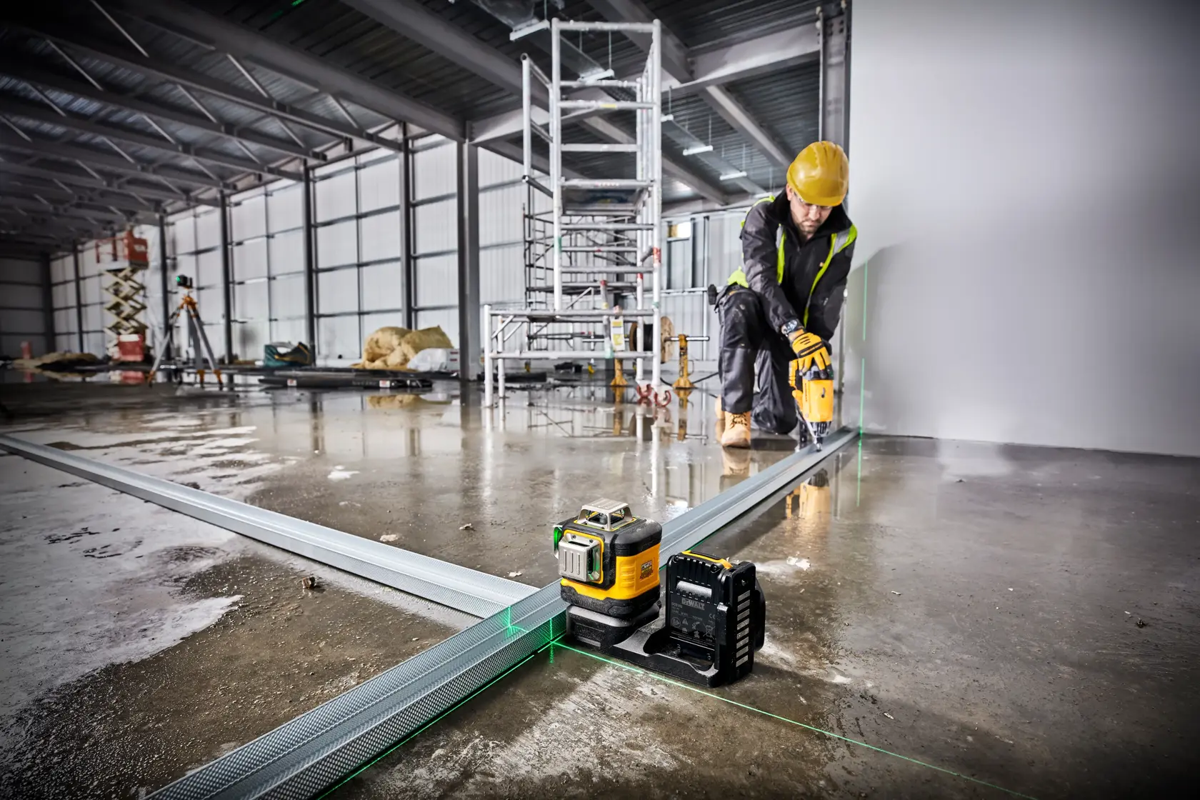 DEWALT Laser wird auf Baustelle genutzt, Arbeiter richtet Metallrahmen mit Sicherheitskleidung aus.