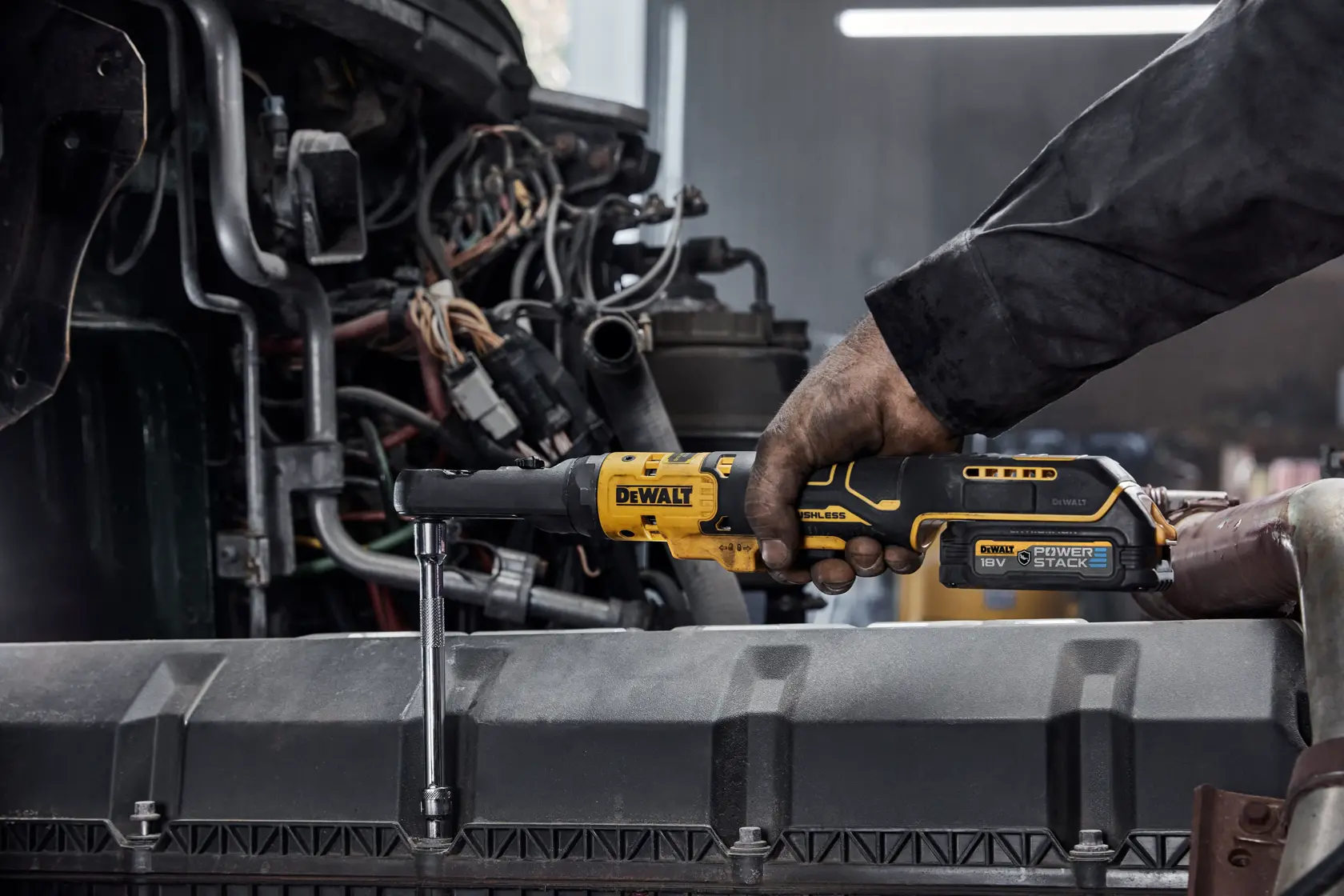 Persona utiliza una llave de carraca inalámbrica DEWALT en maquinaria en un entorno industrial.