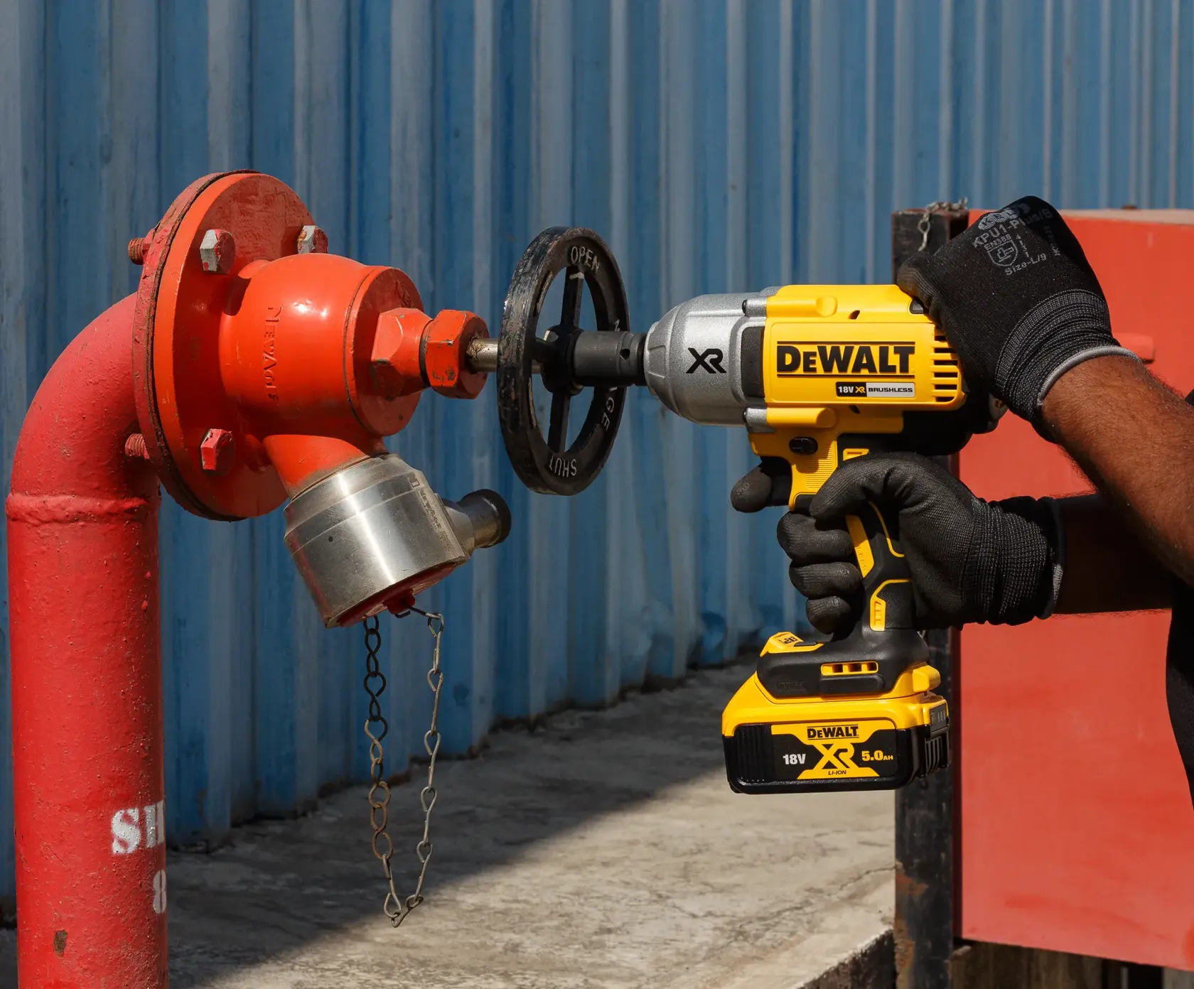 DEWALT DCF899P2 kit includes a 20V MAX XR brushless high torque 1/2 inch impact wrench with detent pin anvil, two 20V MAX 5.0Ah batteries, a charger, and a black and yellow carrying bag. All items are displayed together.