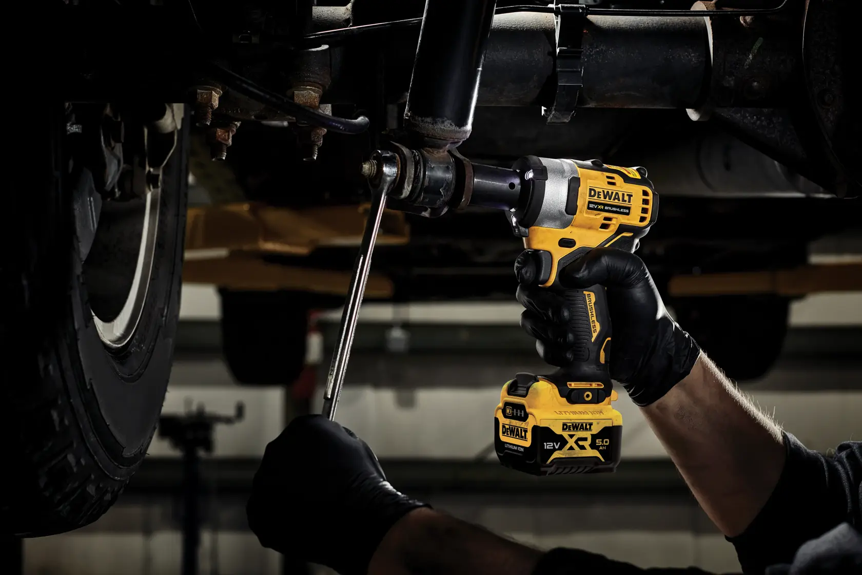 DEWALT DCF901P2, DCF901P2-QW Schlagschrauber im Einsatz unter Fahrzeug. Kategorie Fotografie.