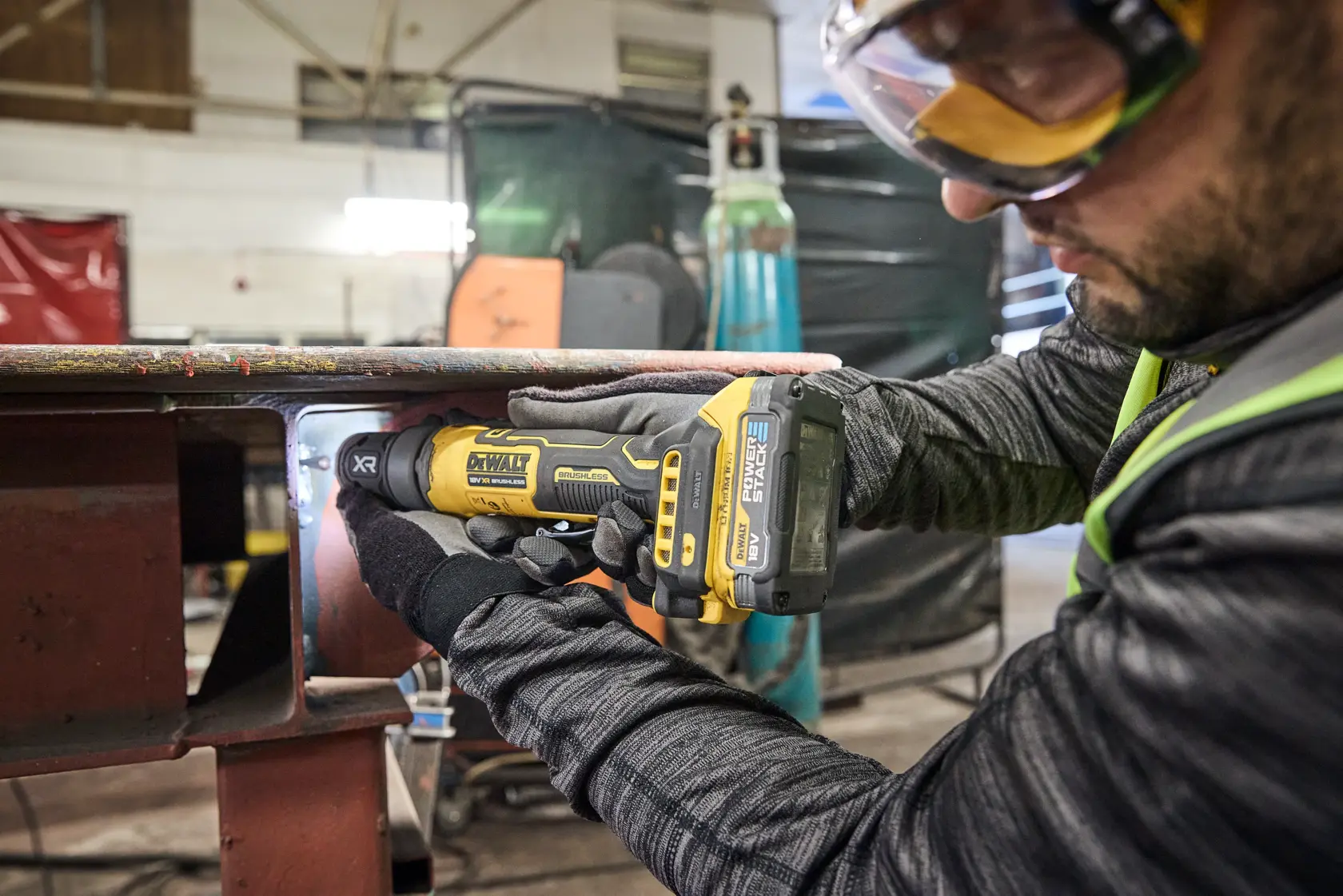 DEWALT DCG420N-XJ, DCG420N amoladora en taller. Operario con guantes usa herramienta. Categoría fotografía.