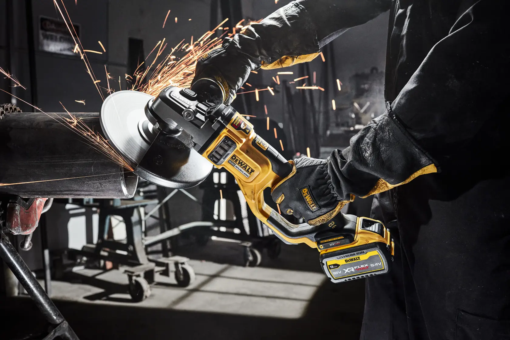 Amoladora inalámbrica DEWALT corta tubo metálico, saltan chispas en taller.
