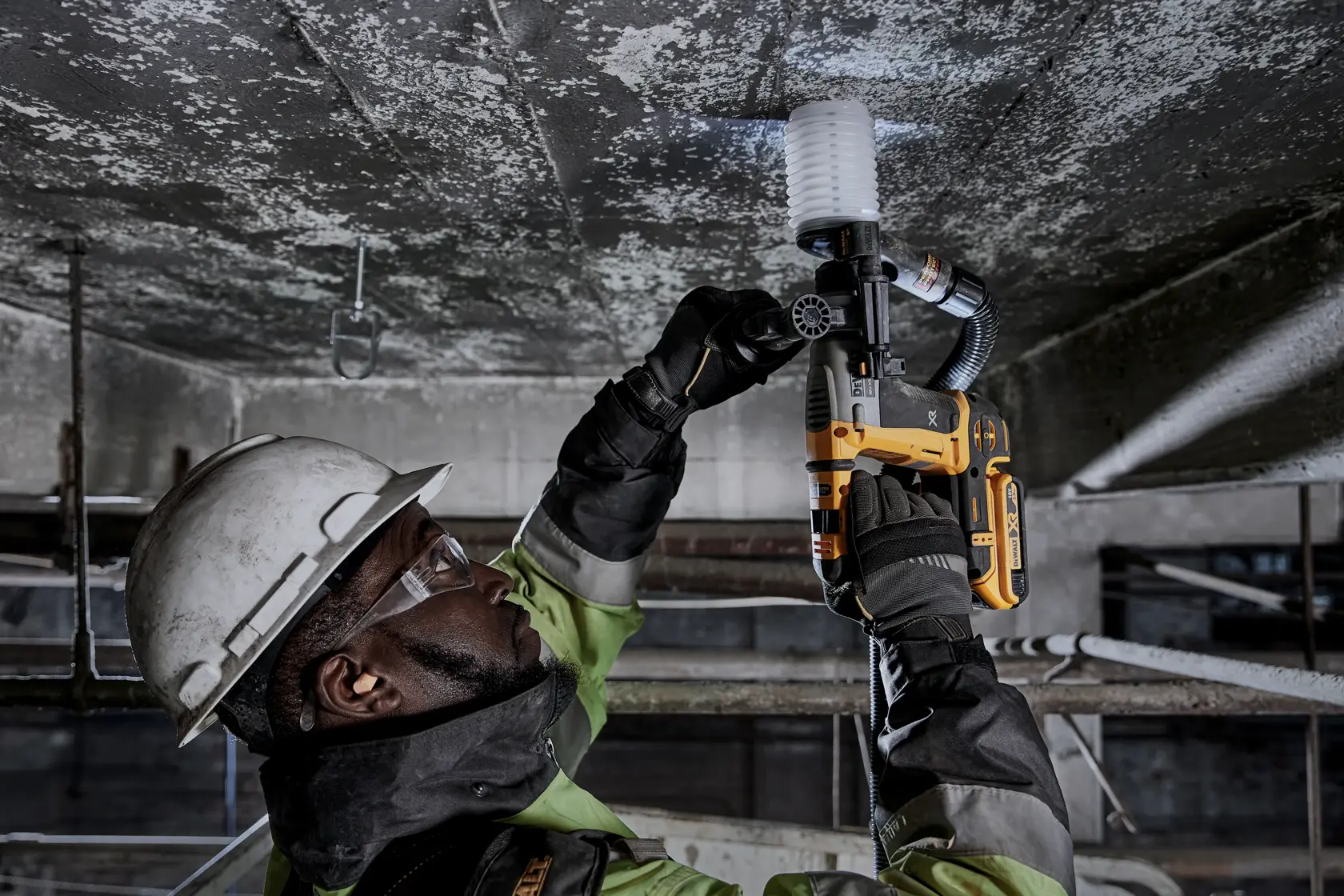 Trabajador usa DEWALT DCH172NT-XJ, DCH172NT en el techo. Entorno industrial, equipo de seguridad.