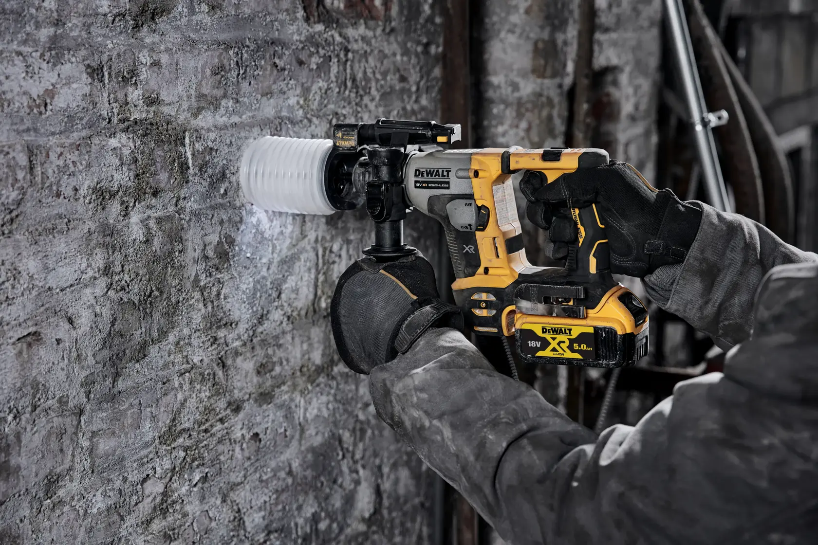 Persona usa taladro rotativo DEWALT sin cable para perforar pared de concreto en obra.