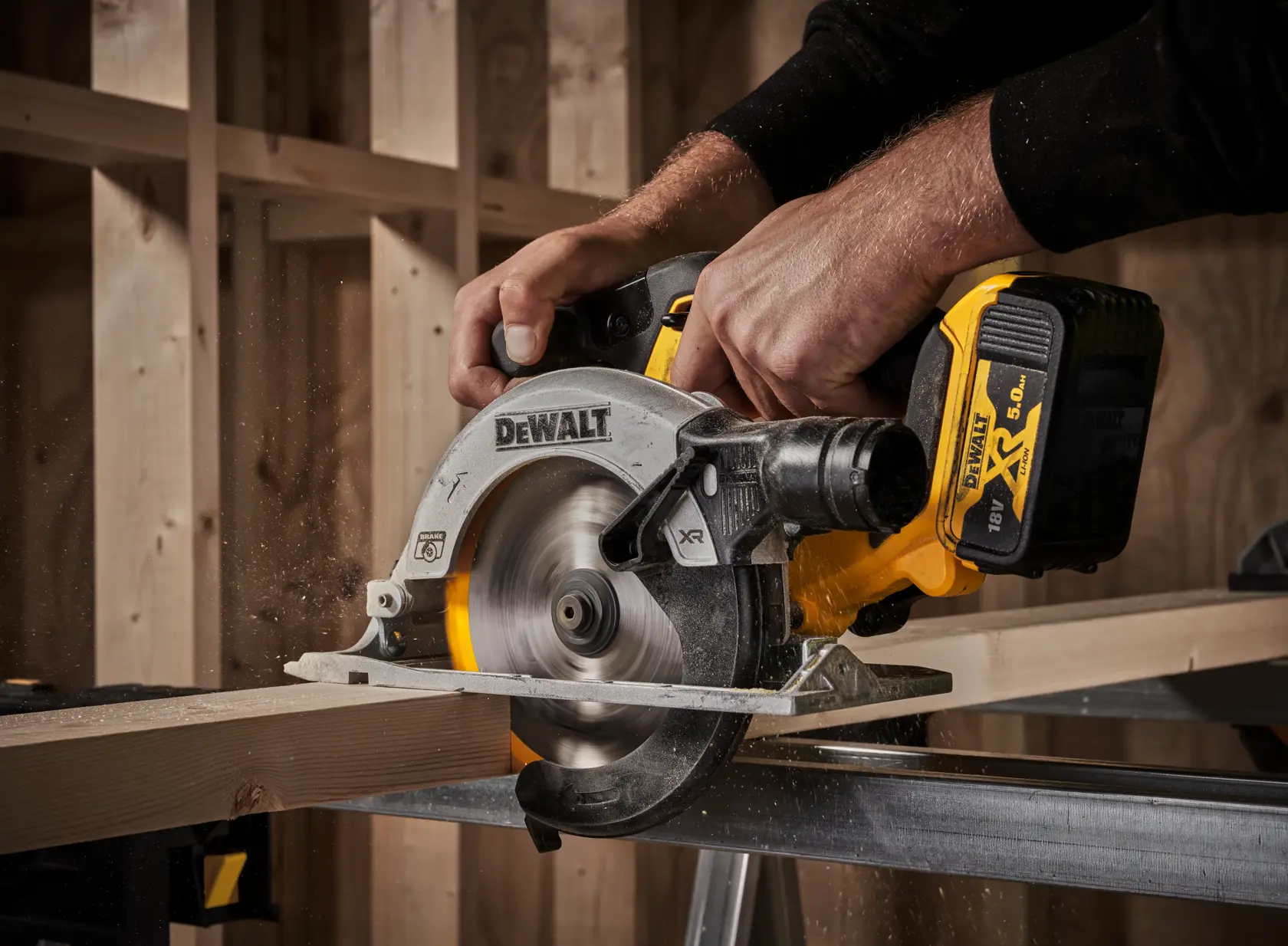 DEWALT cordless circular saw cutting wood, held by a person in a workshop with wooden framing.