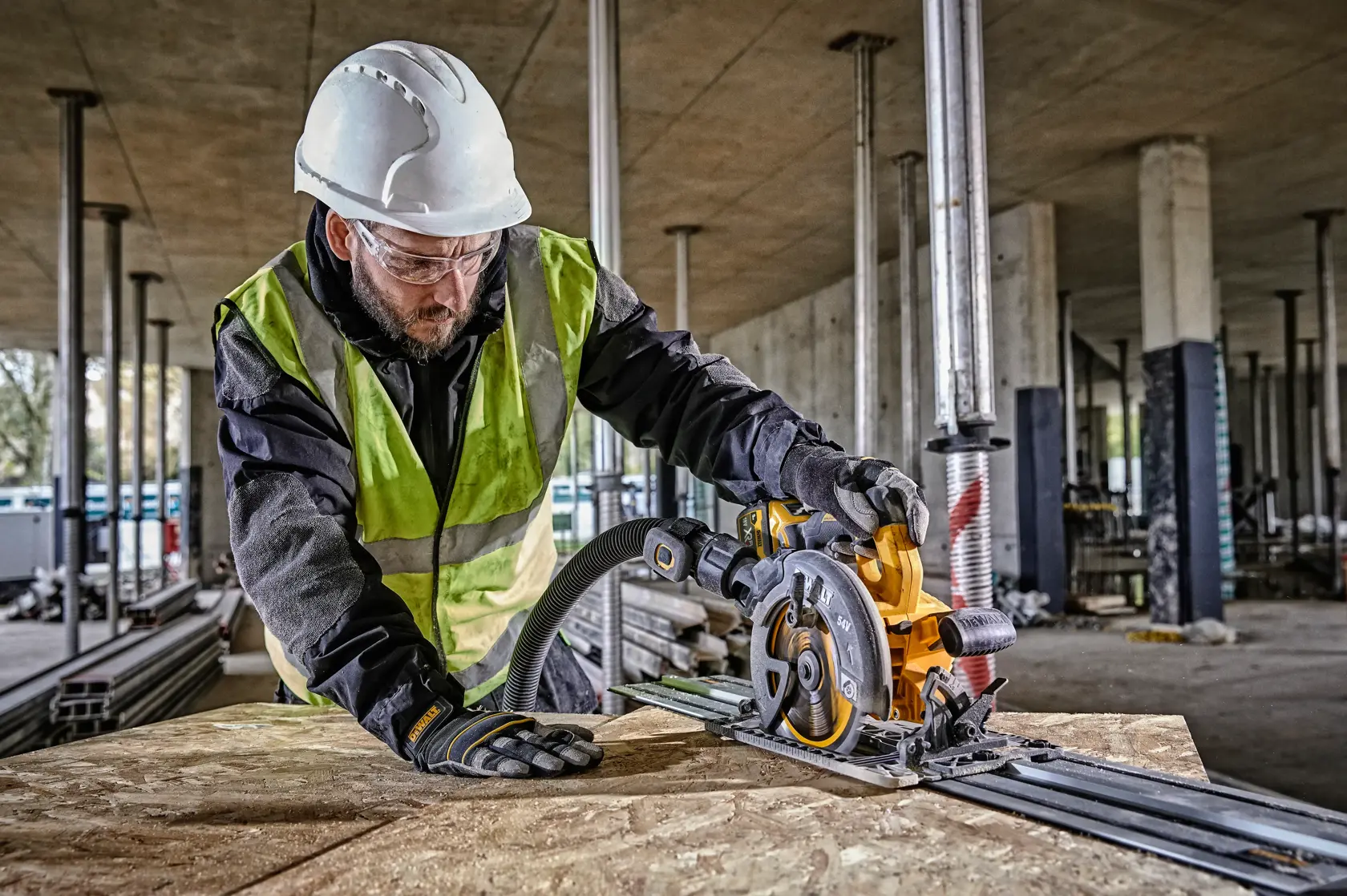 Trabajador usa la sierra circular DEWALT DCS579NT en obra, con equipo de seguridad.