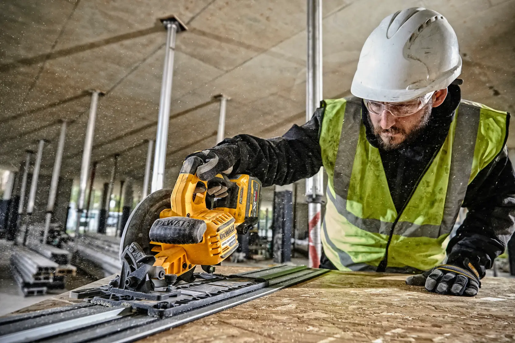 Trabajador usa sierra circular DEWALT DCS579NT para cortar madera en obra, con casco y chaleco de seguridad.