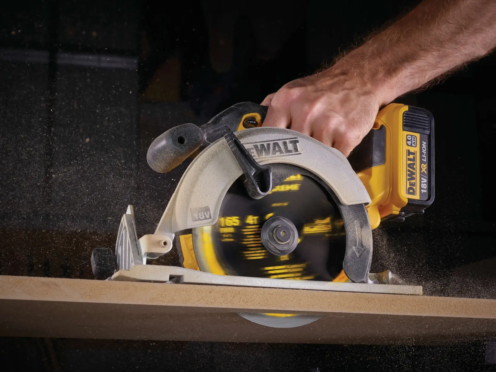Sierra circular DEWALT inalámbrica cortando madera, primer plano de mano y hoja giratoria.