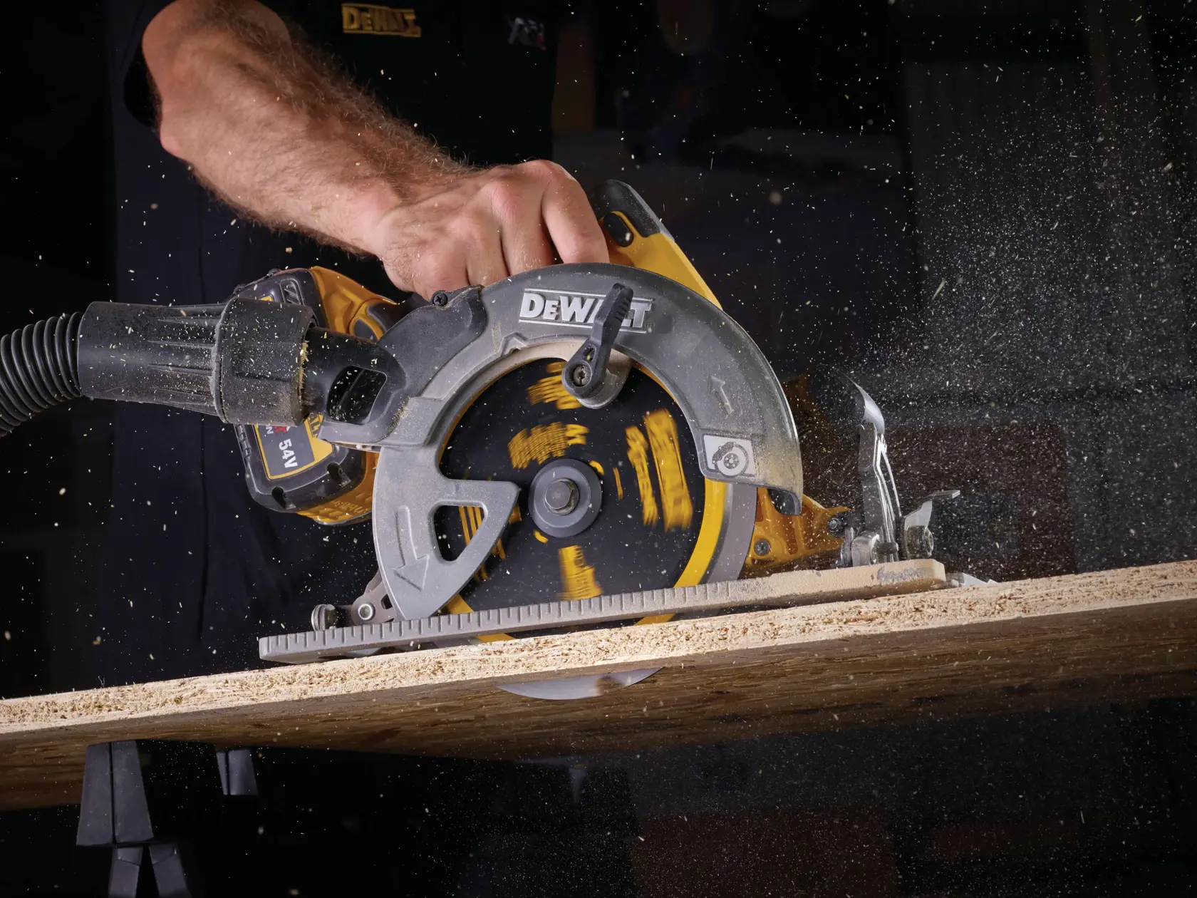 Sierra circular DEWALT cortando madera, aserrín en el aire, mano del operador visible.