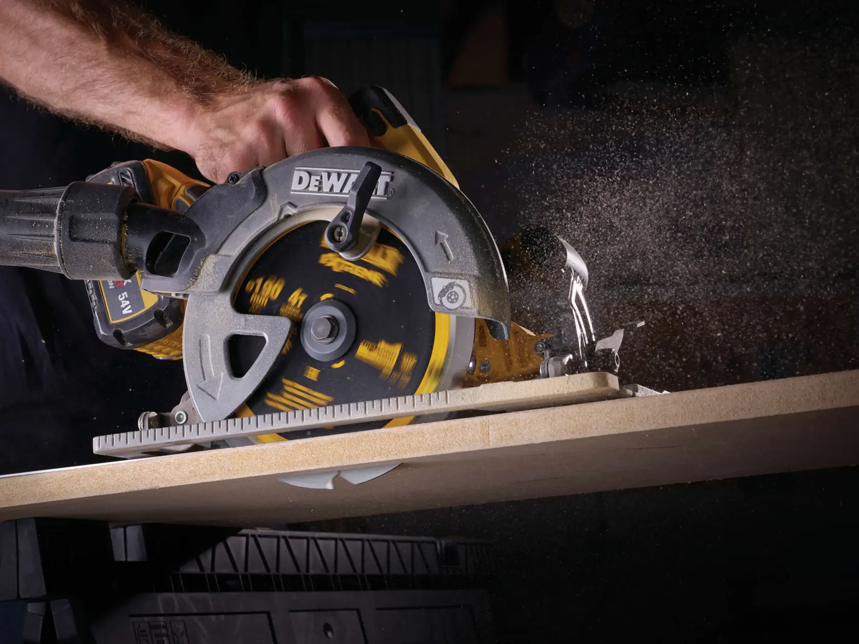 Primer plano de una sierra circular DEWALT cortando madera, con polvo en el aire.