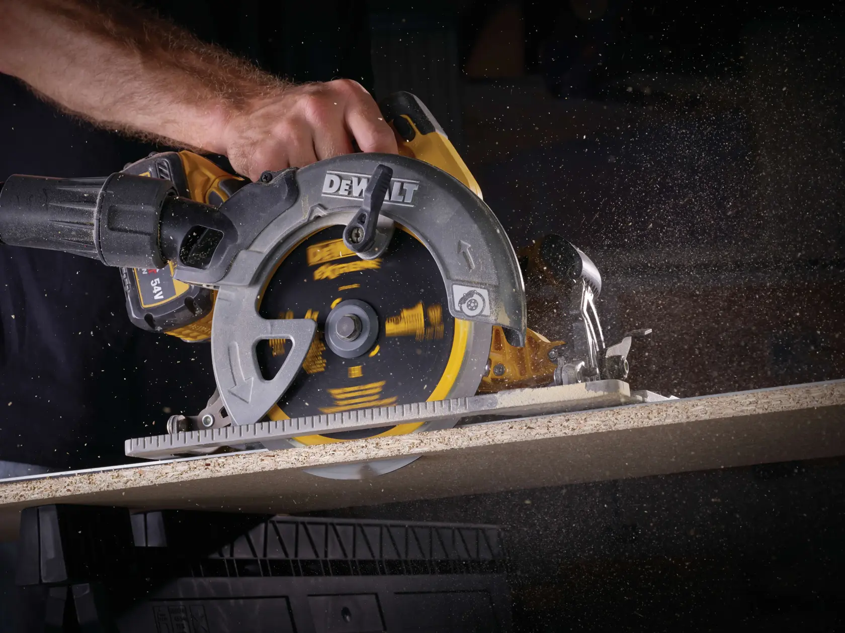 Una sierra circular DEWALT corta madera, con serrín volando mientras gira la hoja.