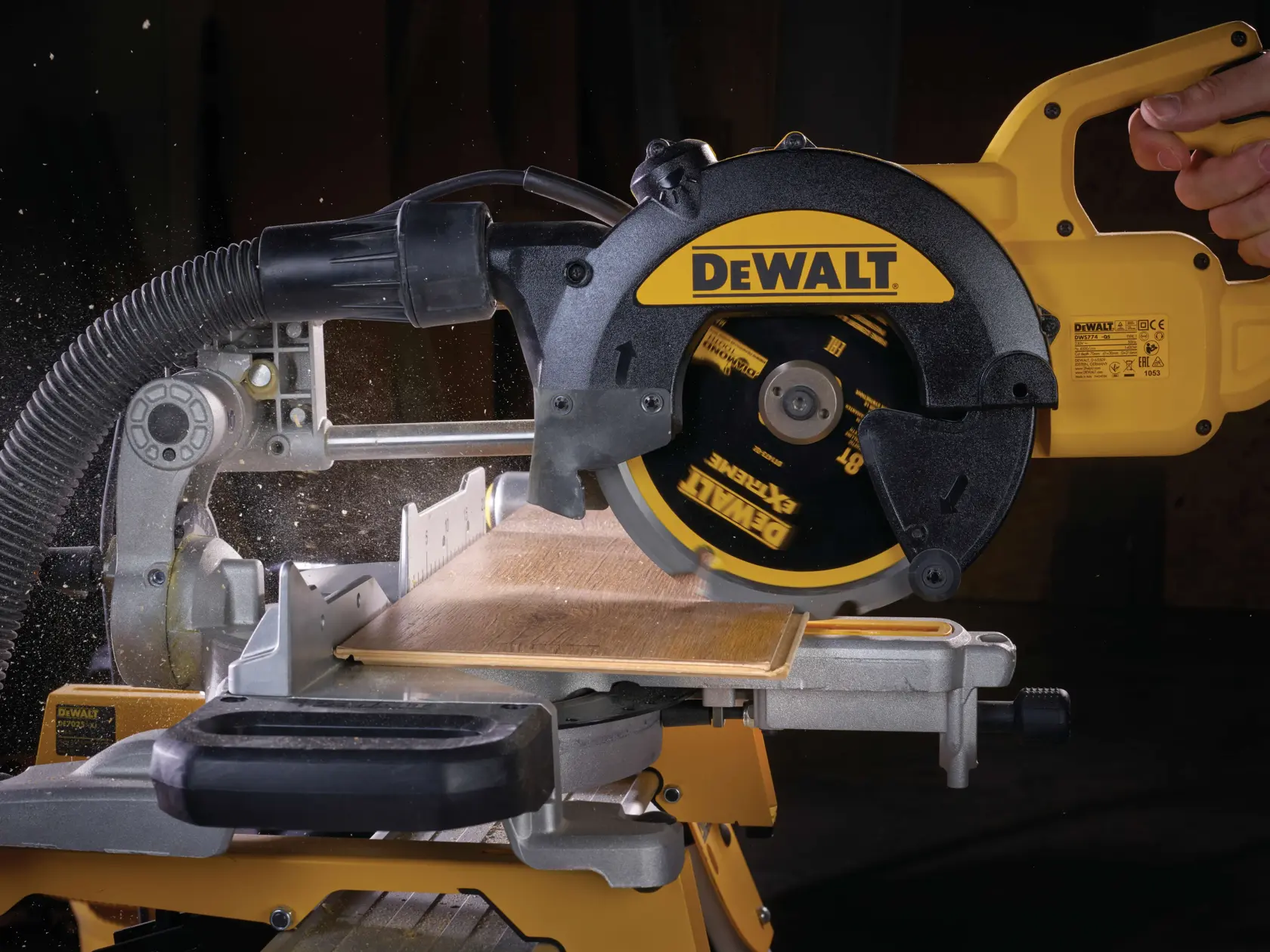Sierra circular DEWALT cortando madera, vista cercana con manguera de extracción, disco en movimiento.