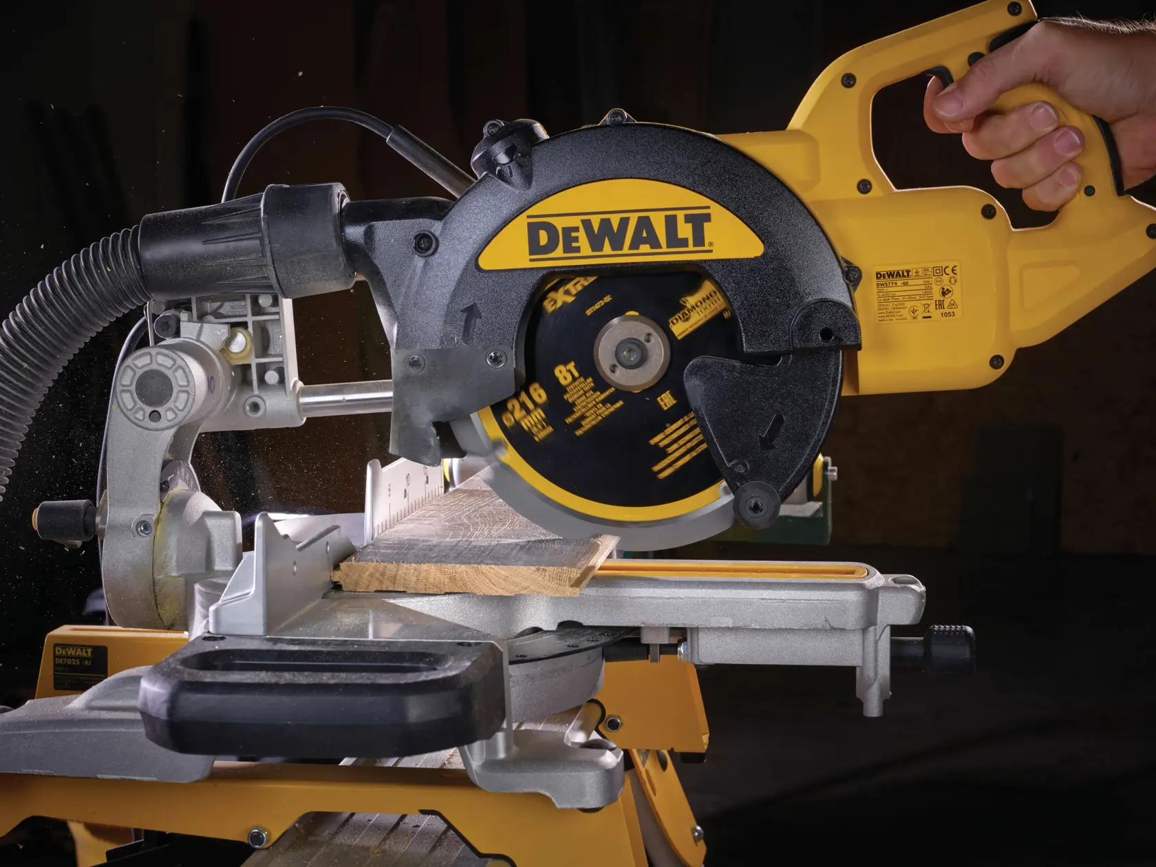 Sierra circular DEWALT corta madera en soporte de inglete, operada por una mano en taller.