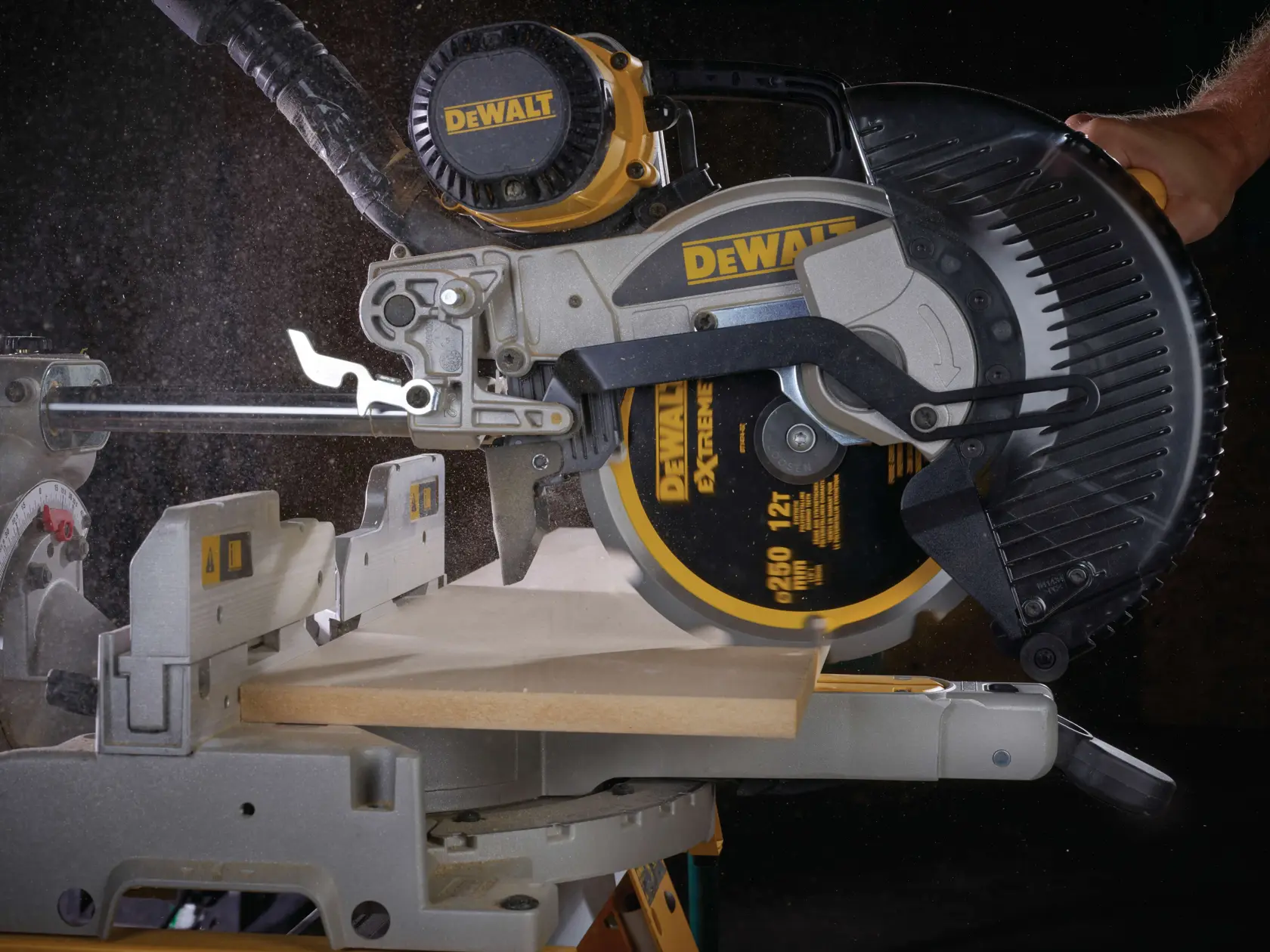 Sierra circular DEWALT corta una tabla de madera; se ve polvo durante el uso.
