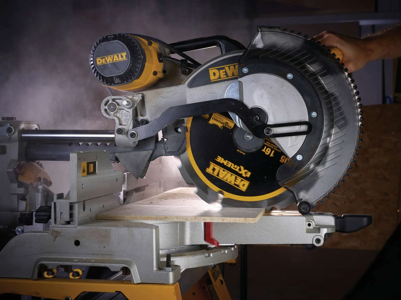 Sierra circular DEWALT corta madera, polvo visible, primer plano de la hoja y mano en el mango.