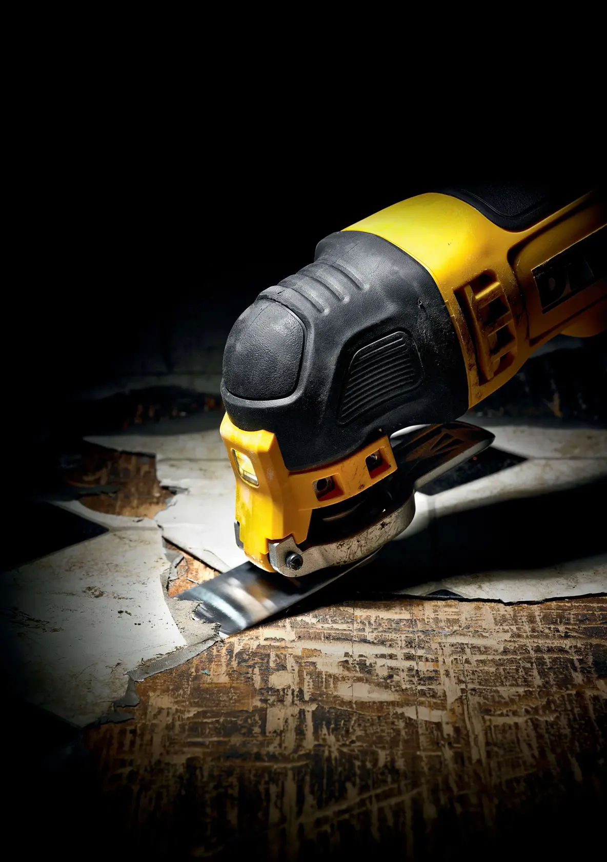 DEWALT oszillierendes Multitool schneidet alten Boden, Nahaufnahme des Geräts und Schnitt.