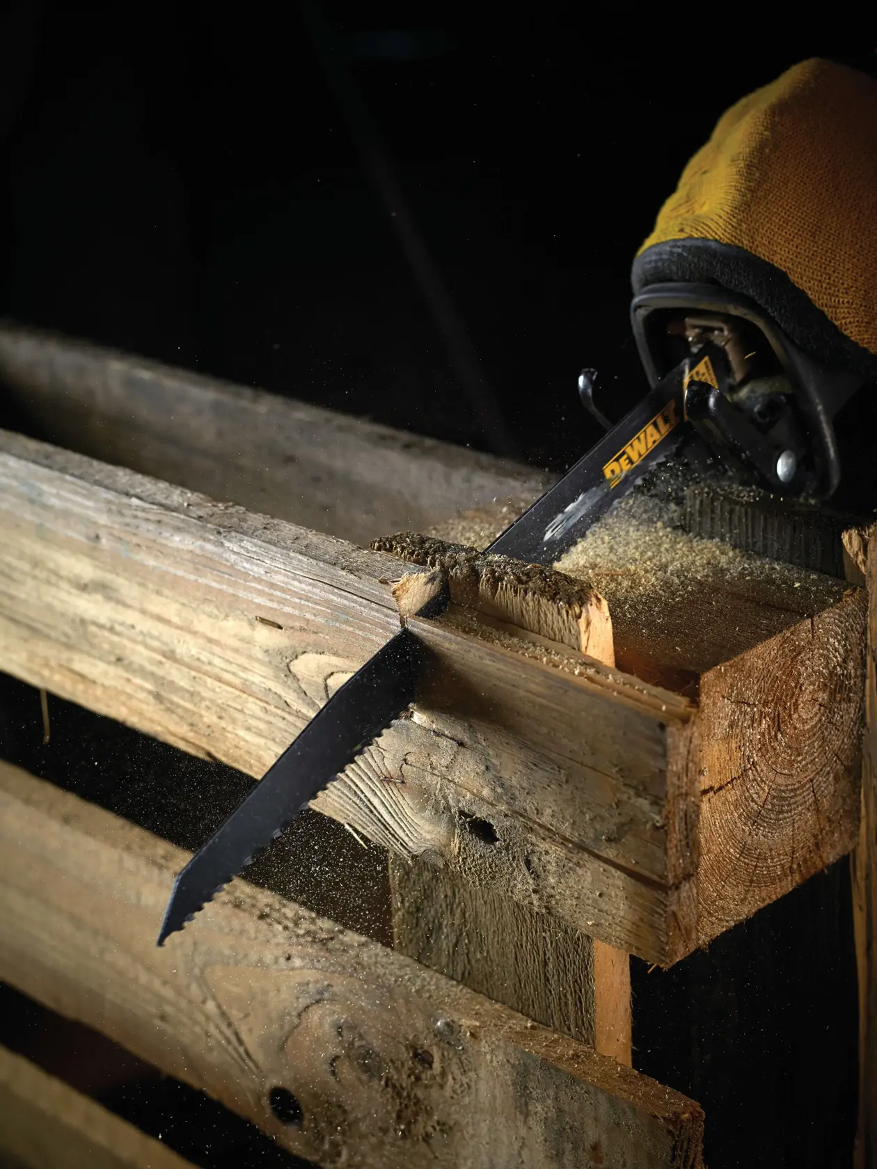Hoja DEWALT corta un pallet de madera, generando aserrín durante trabajo en carpintería.