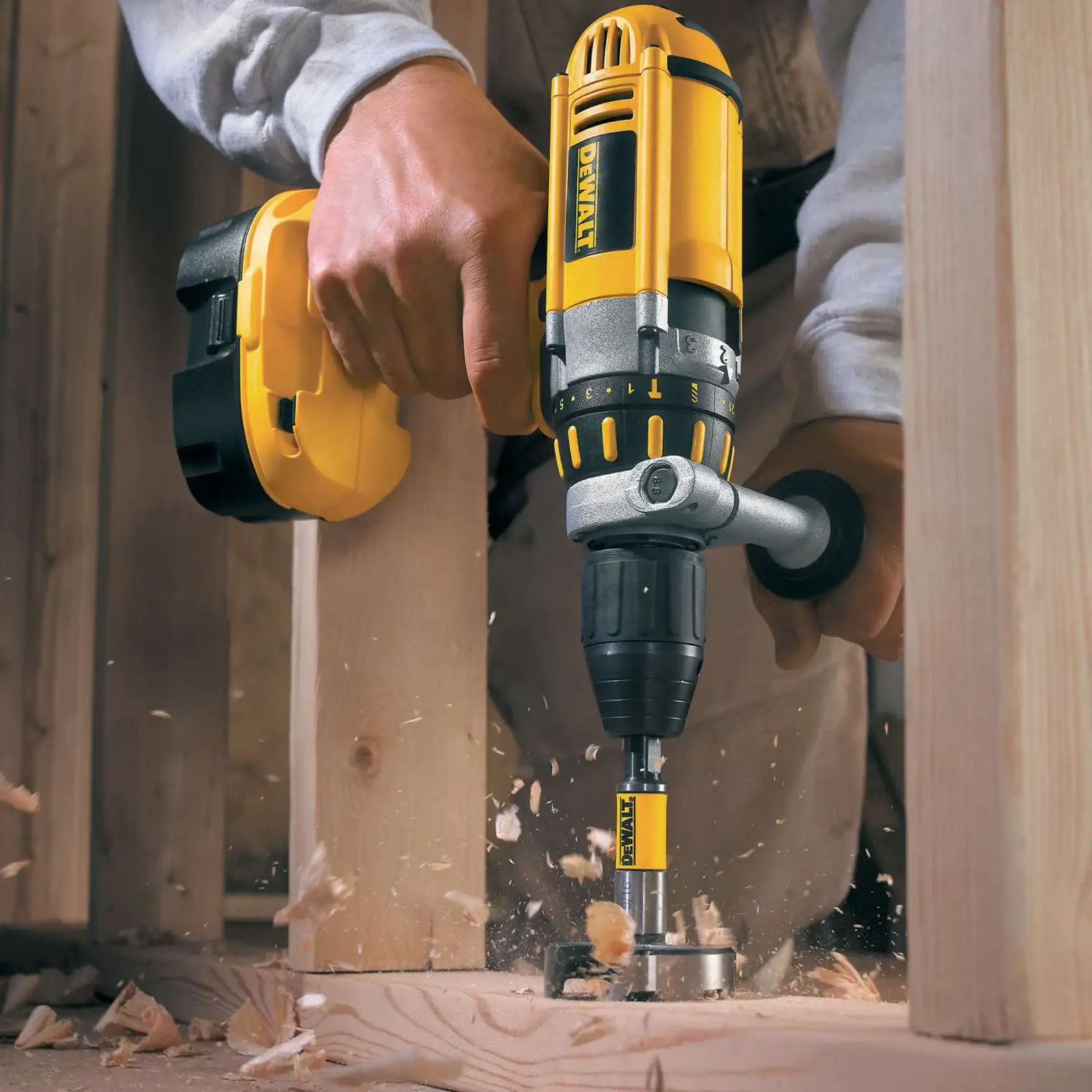 Taladro DEWALT perforando viga de madera, astillas y virutas salen del corte.