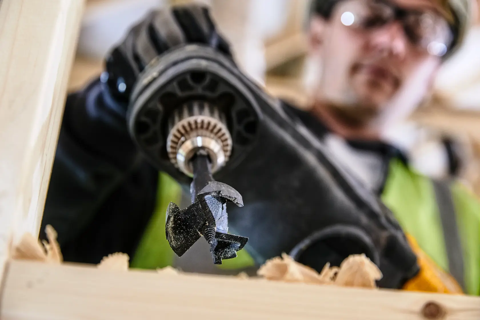 Taladro DEWALT con broca DT4585 perforando madera. Primer plano de herramienta y virutas.