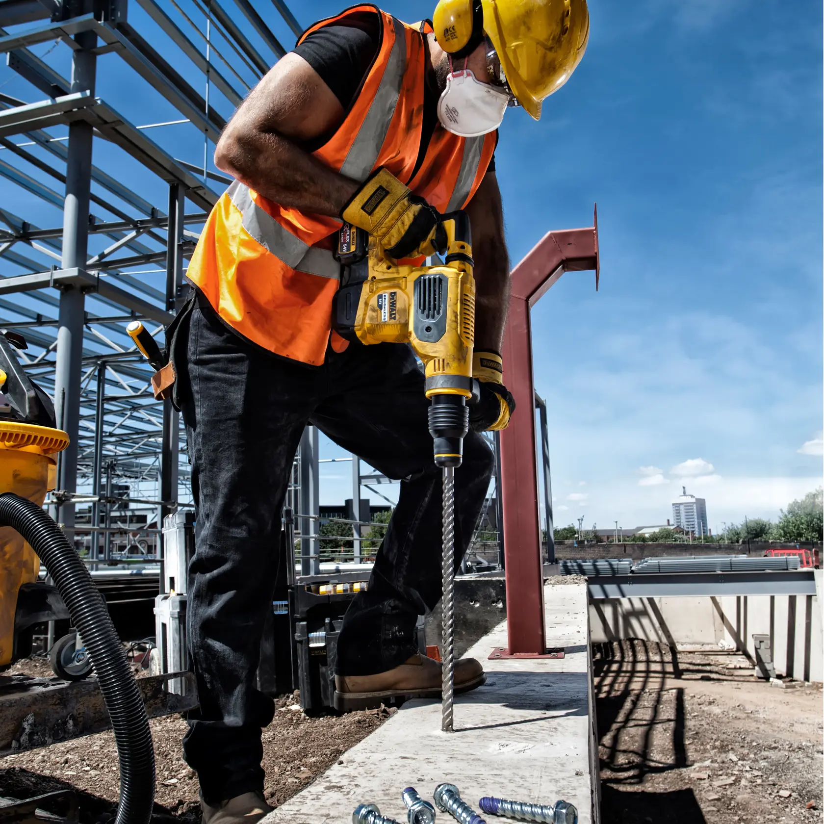 DEWALT DT60814, DT60814-QZ en uso en obra. Trabajador perfora concreto con herramienta eléctrica amarilla.