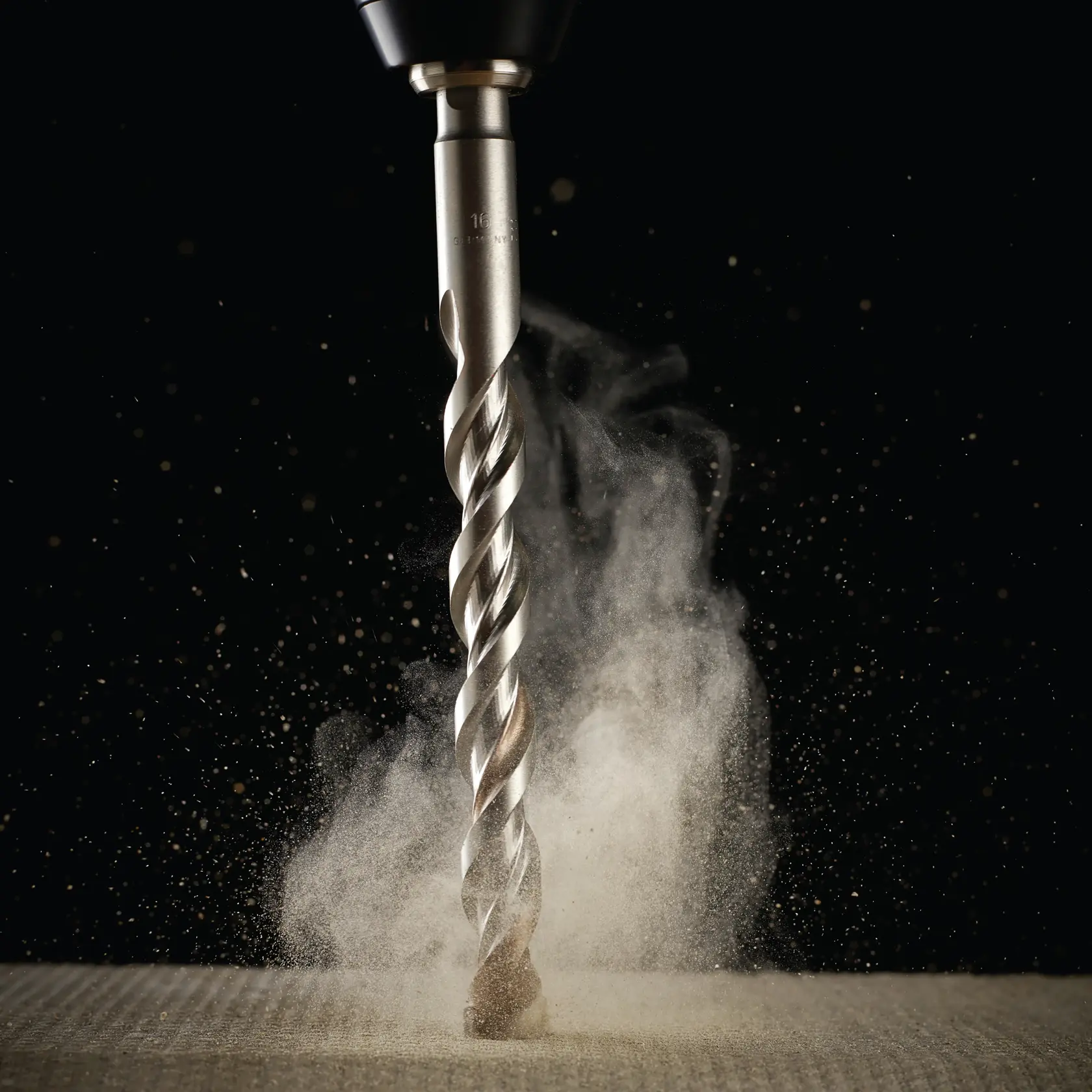 Primer plano de broca DEWALT perforando material, polvo rodeando la espiral metálica.