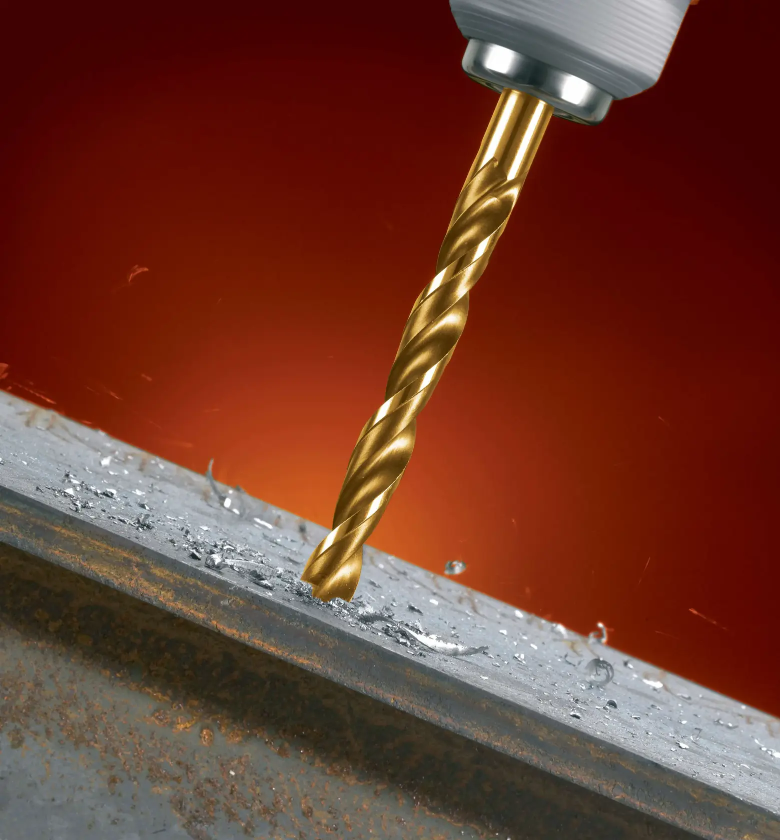 A close-up of a DEWALT drill bit boring into a piece of metal, with metal shavings scattered around the drilled area against a red background.