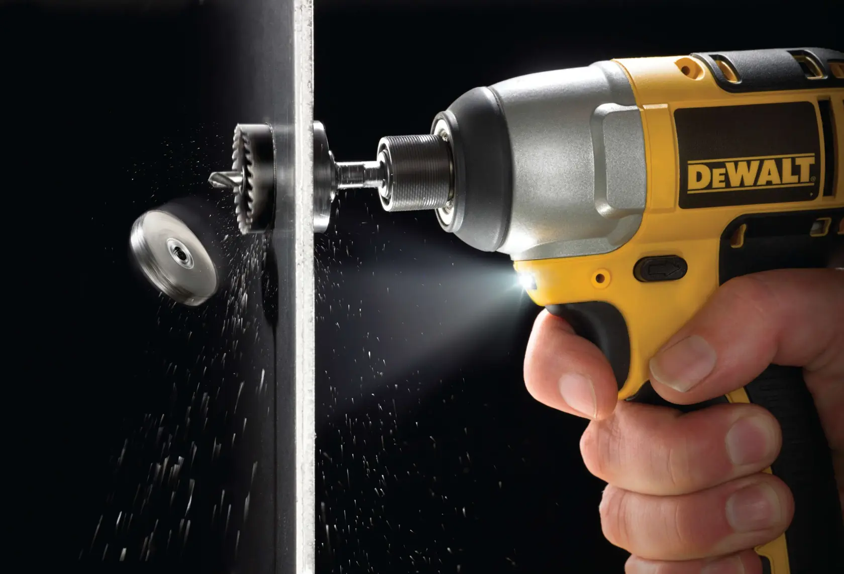 DEWALT drill making a precise hole in a metal sheet, metal shavings visible, close-up of tool and hand.