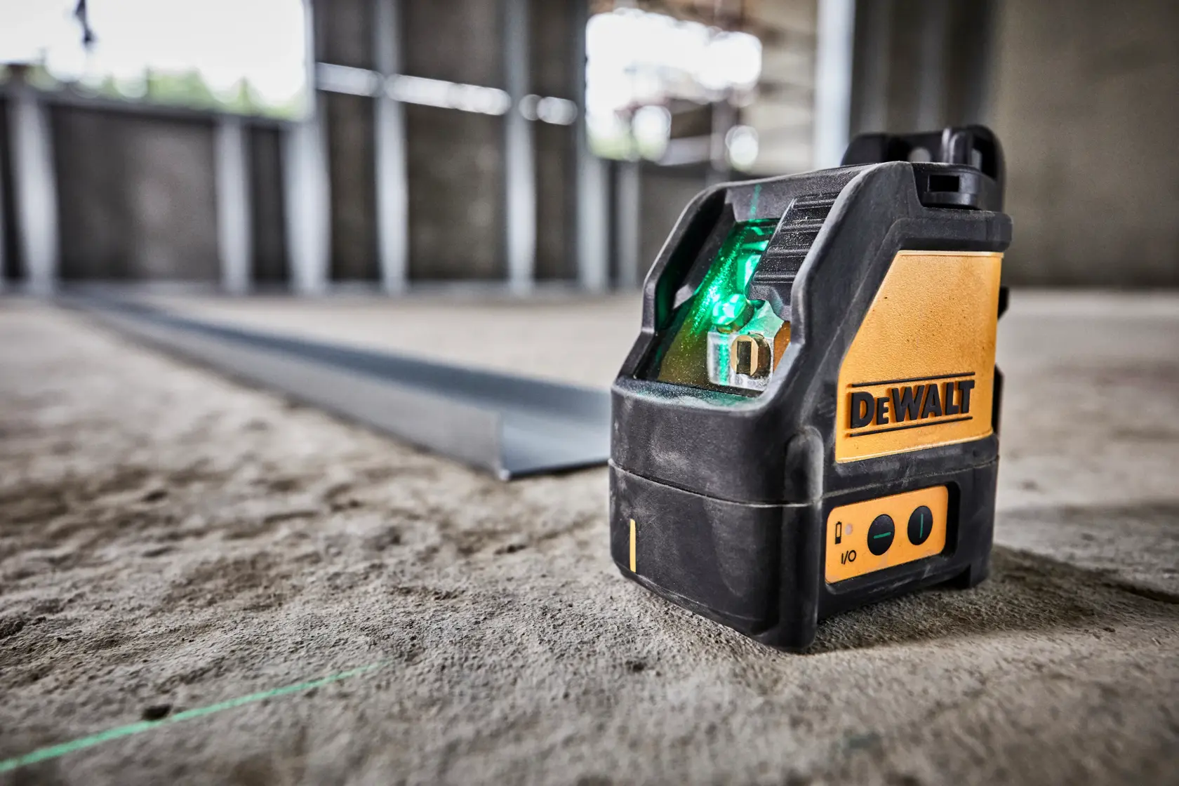 Kit de láser de línea en cruz DEWALT DW088CG con maletín rígido de transporte, tres baterías alcalinas AA y soporte de pared, mostrado sobre un fondo claro.