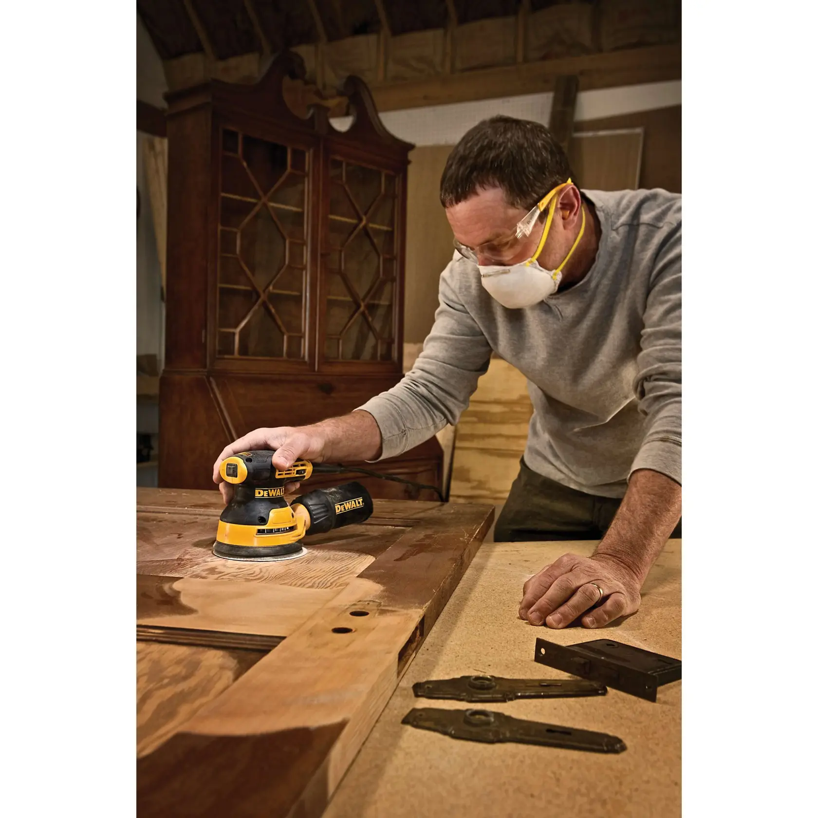 Image of a DEWALT random orbit sander with several features labeled: 3 amp motor, hook and loop backing system, 8,000-12,000 OPM speed range, and rubber overmold grip. The tool is yellow and black in color and has a dust bag attached.