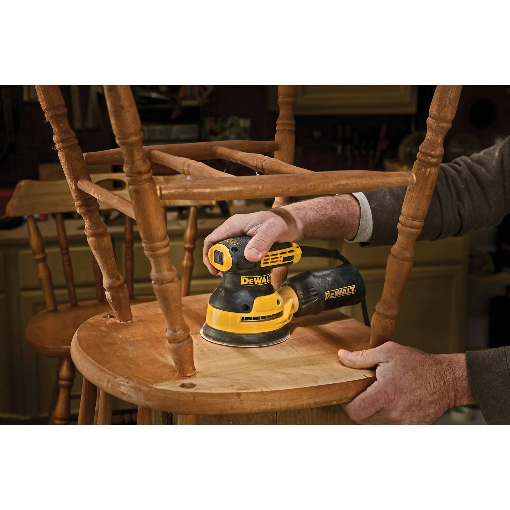 A DEWALT DWE6423 random orbital sander is shown with product features labeled. The sander is yellow and black, with a dust-sealed switch, a separate counterweight design, and a dust port attached to a dust bag.
