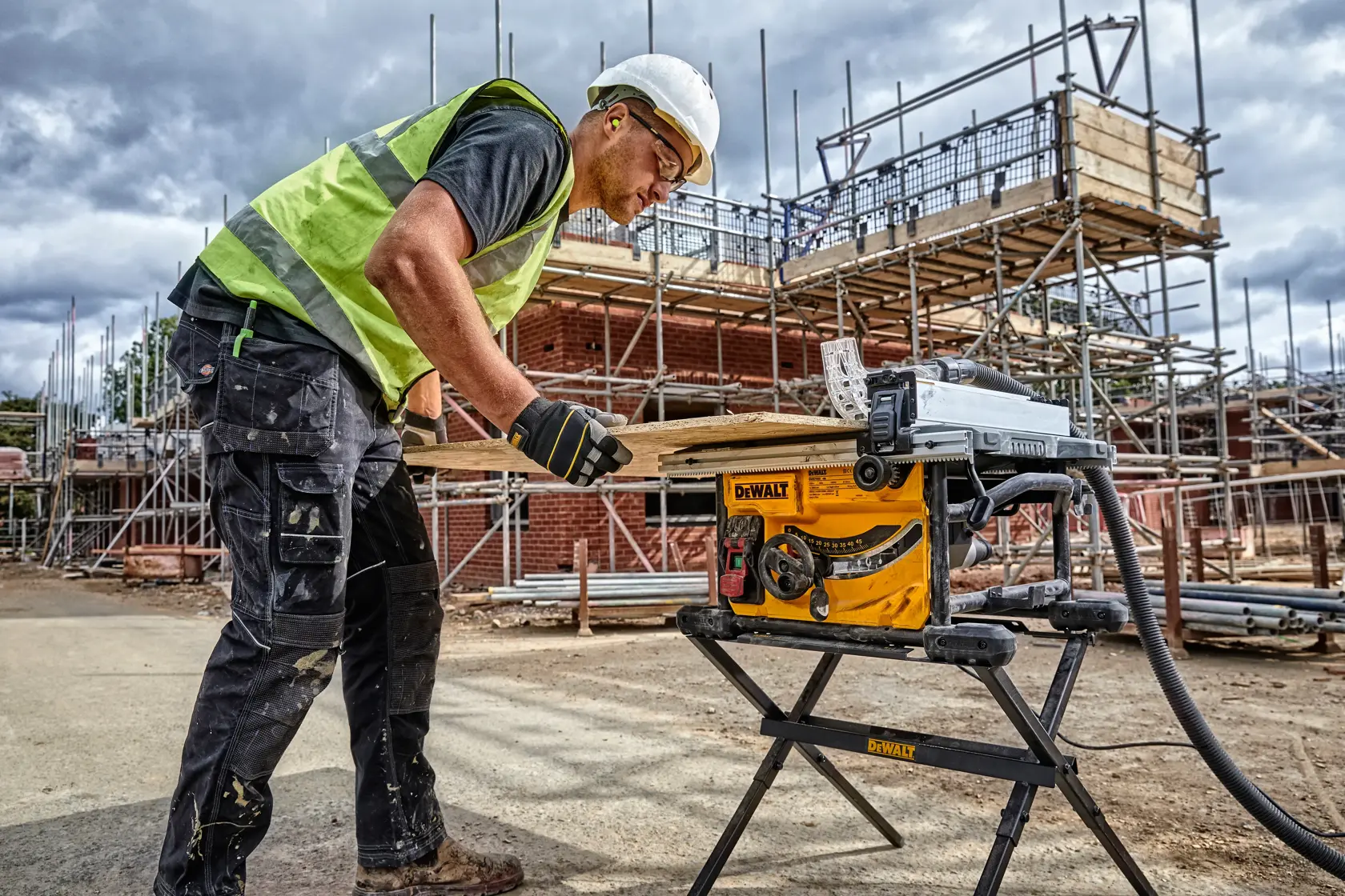 DEWALT DWE7485WS y DWE7485 usadas en construcción. Trabajador corta madera. Andamios atrás.
