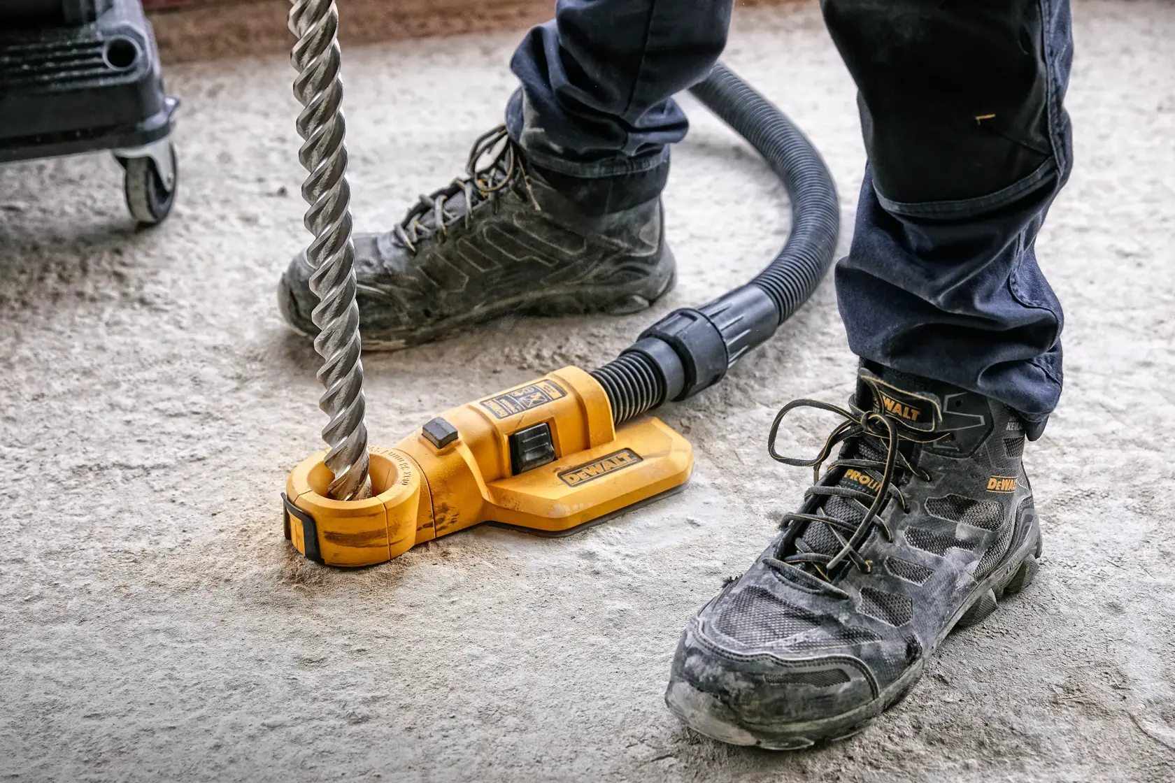Herramienta DEWALT DWH050, DWH050K, DWH050-XJ para taladrar, usada sobre piso de concreto por trabajador.