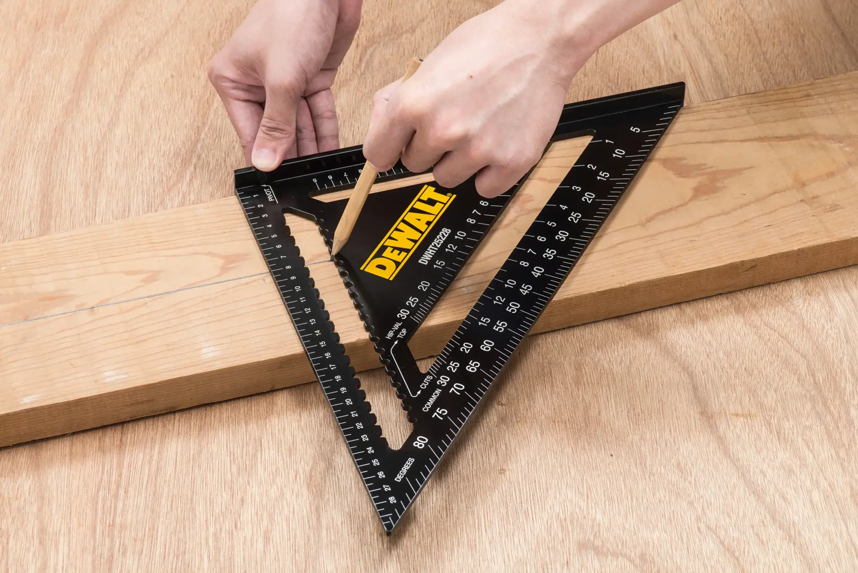 Persona usando una escuadra de carpintero triangular negra DEWALT DWHT25228-0 para marcar una línea recta en una tabla de madera con un lápiz.