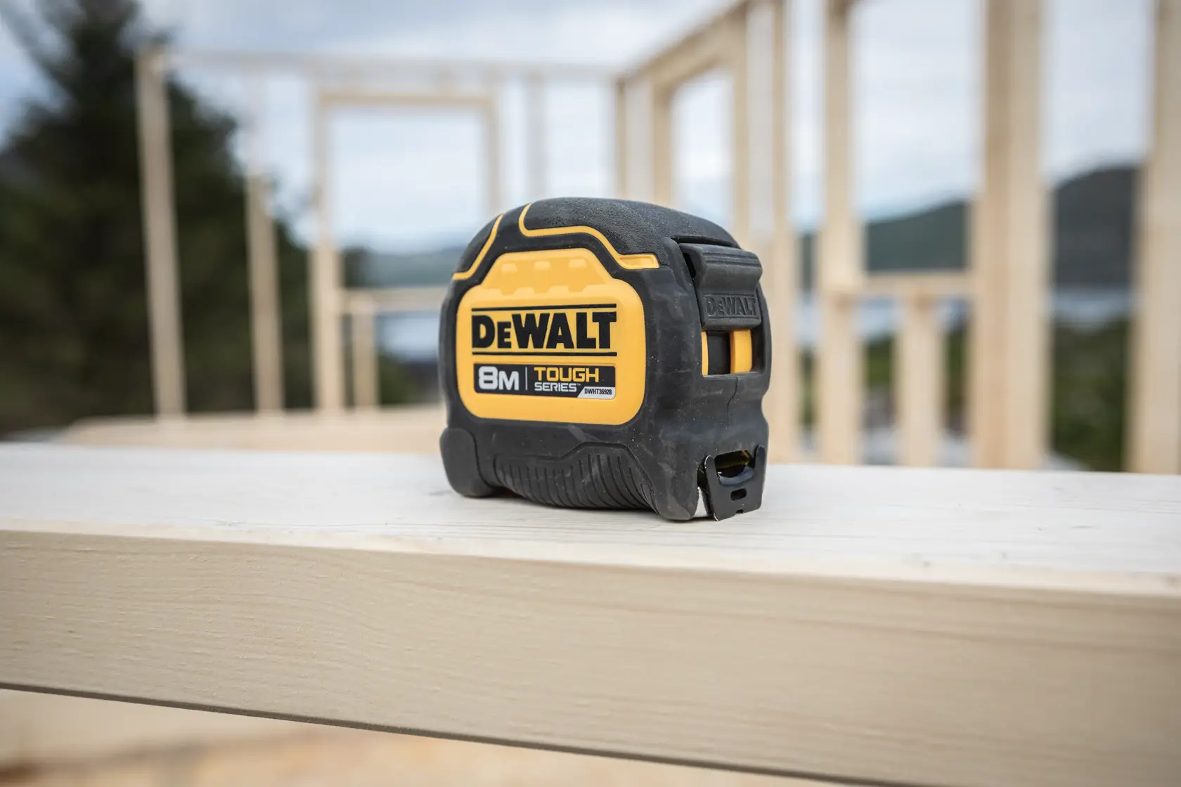 DEWALT 8-Meter Tough Series Maßband auf einem Holzträger an einer Baustelle.