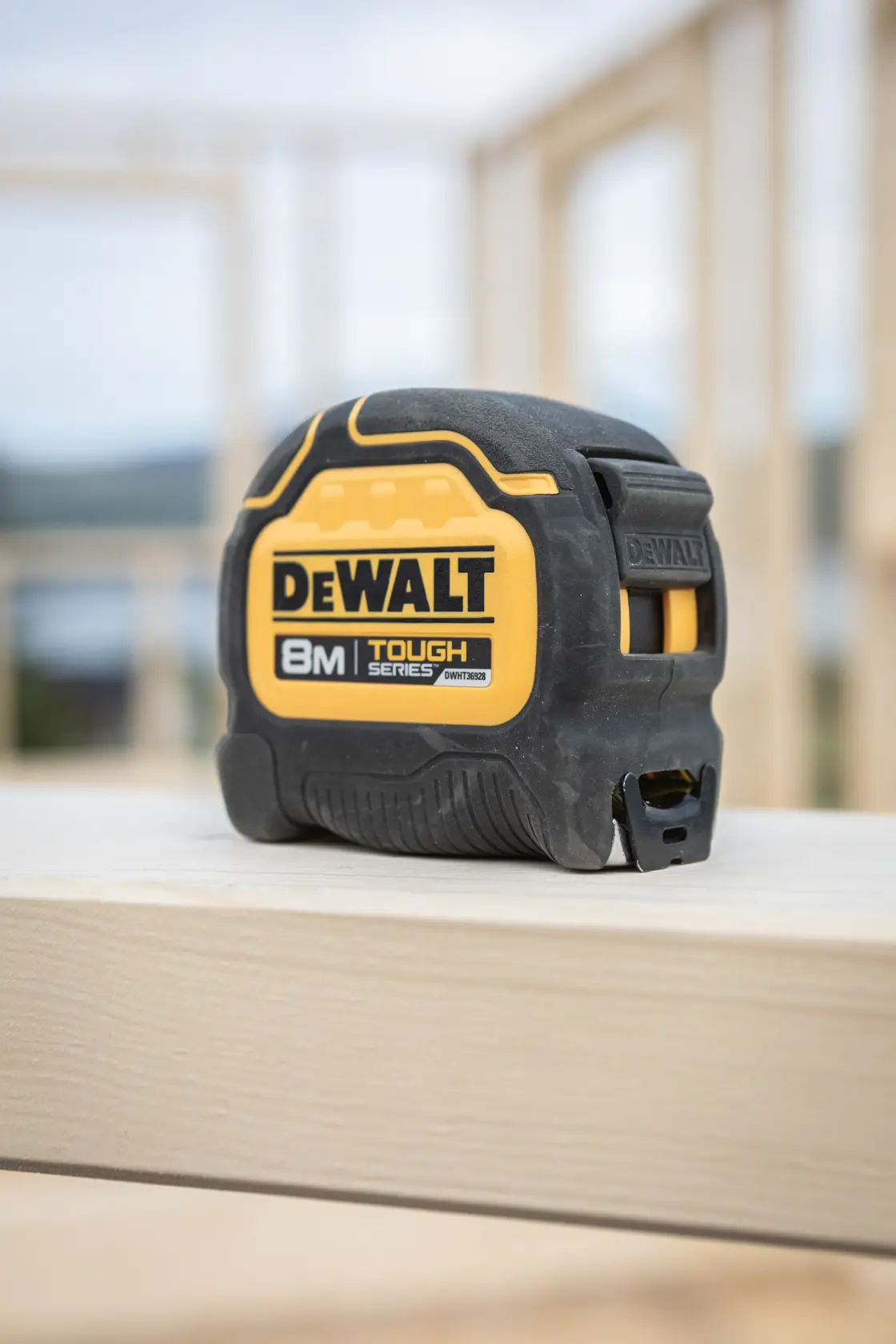 DEWALT 8m Tough Series Maßband auf einem Holzbrett an einer Baustelle.