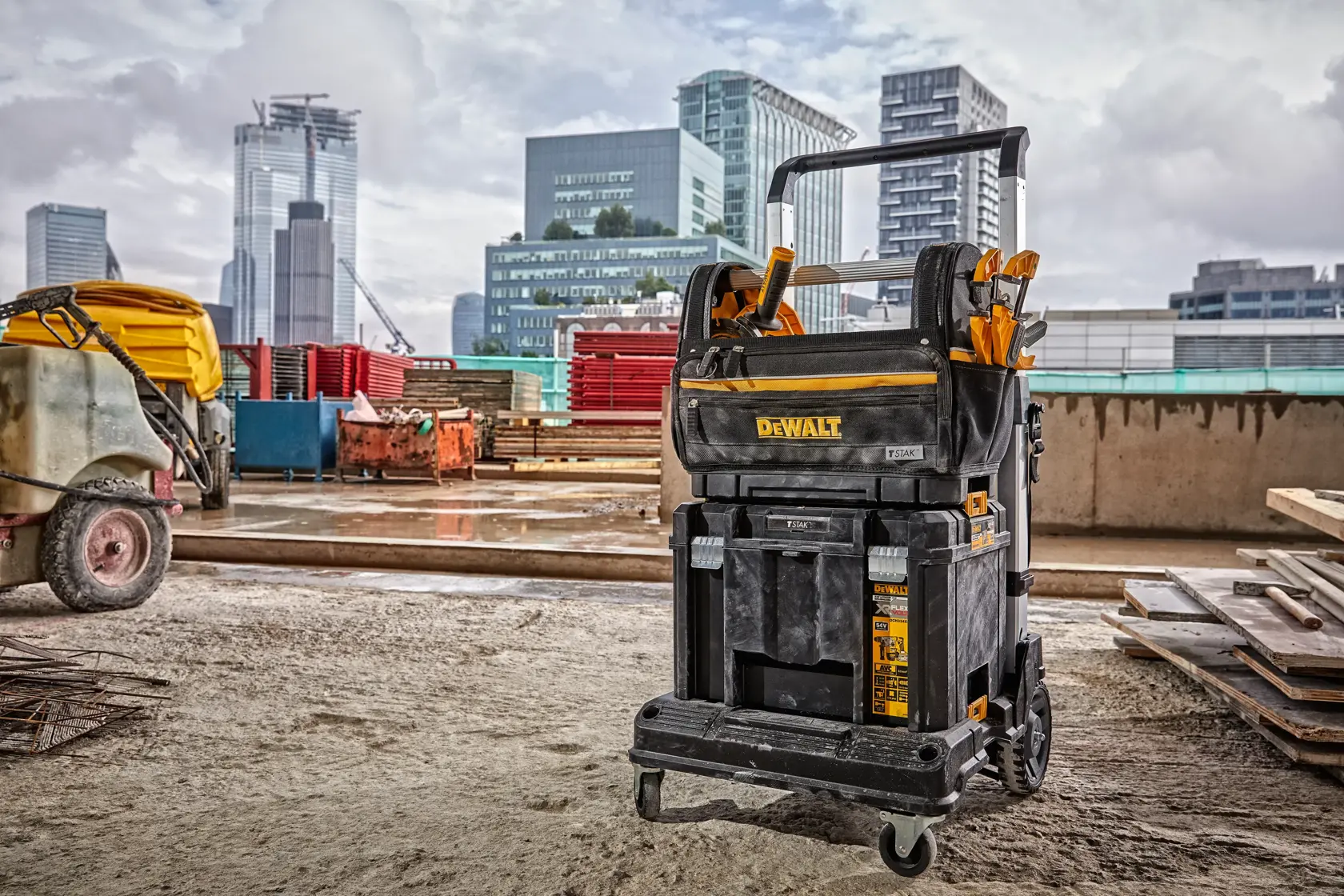 Carro móvil para herramientas DEWALT en una obra con edificios urbanos al fondo.