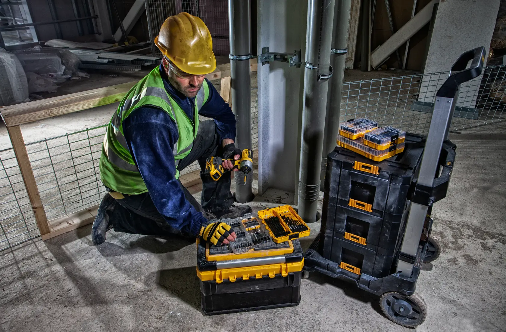 DEWALT DWST83454-1, DWST1-71196, DT70758 almacenamiento herramientas en obra. Categoría fotografía. Trabajador arrodillado.